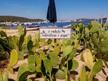 Information sign on beach against sky