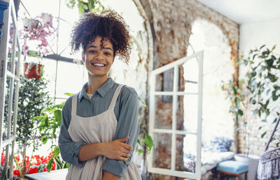 Young woman standing against window