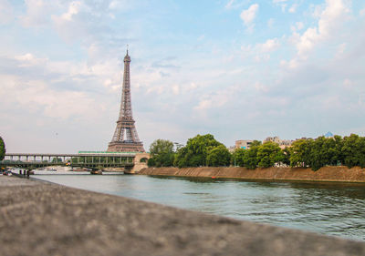Tower in city against cloudy sky