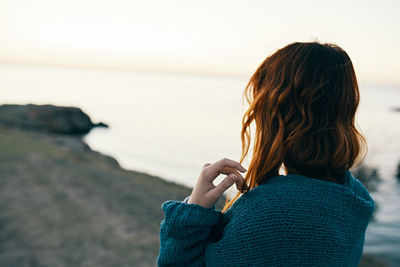 Rear view of woman looking at sea against sky