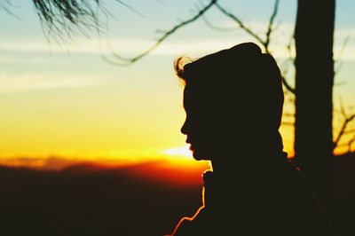 Close-up of silhouette boy against sky during sunset