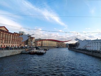 Bridge over river in city against sky