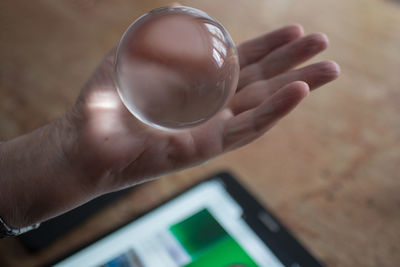Close-up of hand holding crystal ball