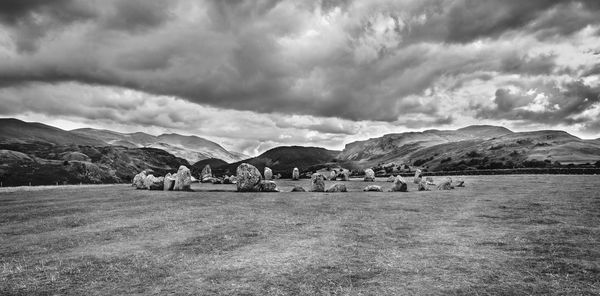 Scenic view of field and mountains against sky