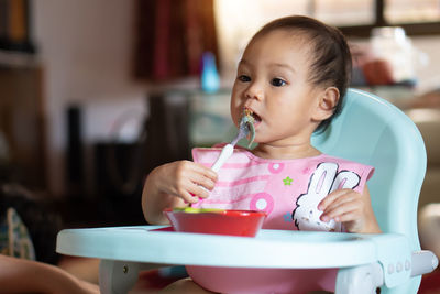 Portrait of cute girl sitting at home