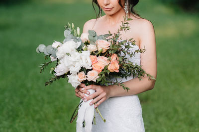 Beautiful woman standing by flower on field