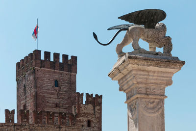 Low angle view of statue of historic building against sky