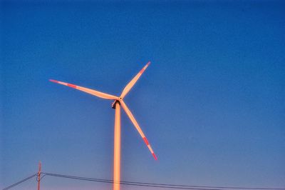 Low angle view of windmill against clear blue sky
