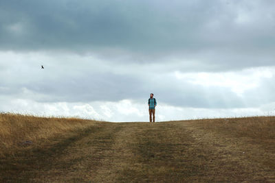 Man standing on field against sky