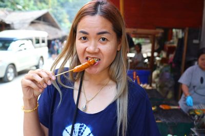 Portrait of woman eating food at restaurant