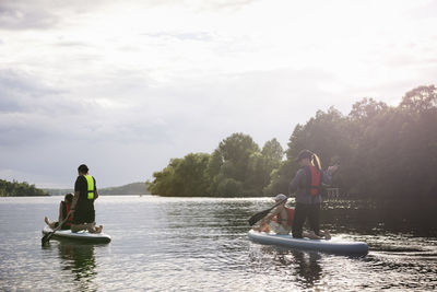 Mother and children paddle boarding