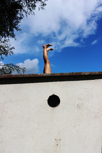 View of person doing handstand behind wall