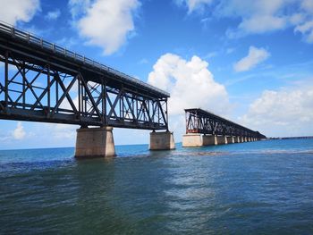 Low angle view of bridge over sea against sky