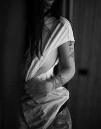 Midsection of woman standing against curtain