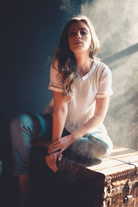 Beautiful young woman sitting on seat at home