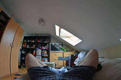 Low section of man sitting on sofa at home