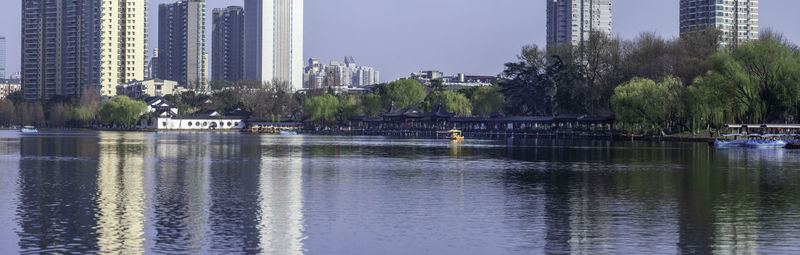 Scenic view of lake by buildings against sky