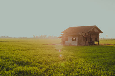 Barn on field against clear sky