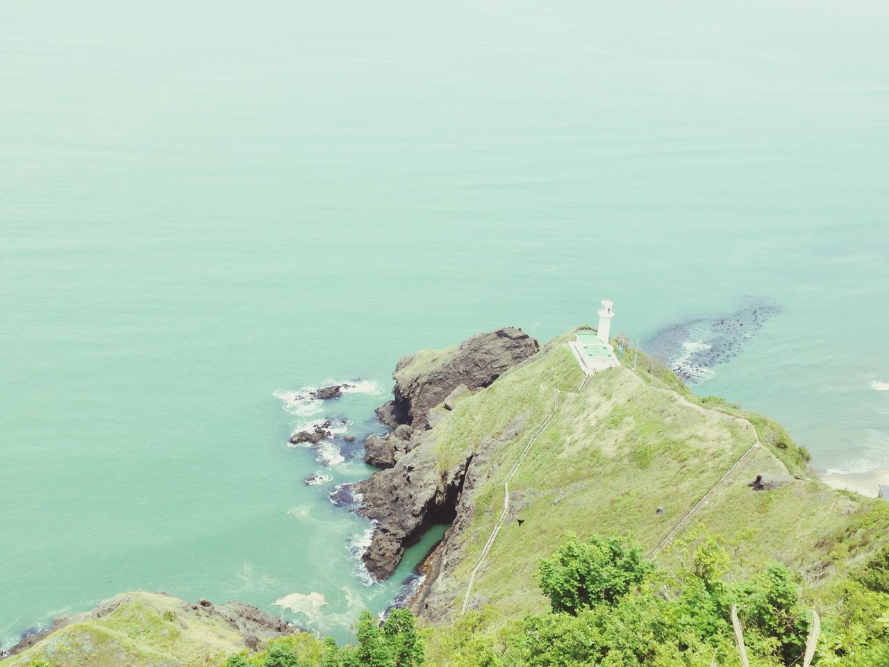 water, sea, tranquility, tranquil scene, scenics, high angle view, beauty in nature, nature, blue, rock - object, cliff, mountain, built structure, idyllic, rock formation, day, horizon over water, green color, architecture, lighthouse