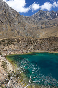 Scenic view of lake by mountain against sky