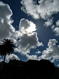 Low angle view of silhouette trees against blue sky