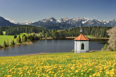 Scenic view of house and mountains against sky