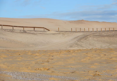 Sand dunes in desert against sky