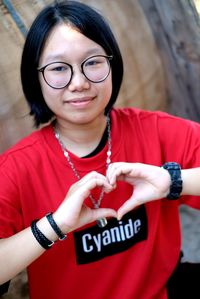 Portrait of girl making heart shape gesture