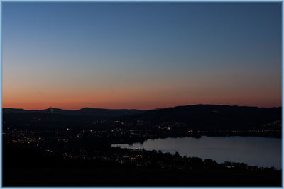 Silhouette cityscape against clear sky at night