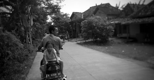 Man riding scooter with girl on road
