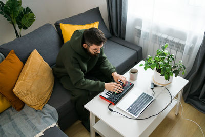 Man using laptop while sitting on sofa at home