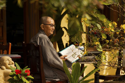 Midsection of monk reading book