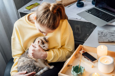 Mental health and work. work life balance. young woman with cat lighting candles, relaxing and