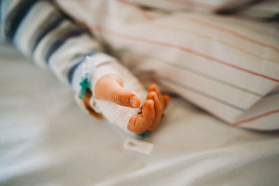 Baby child hand with iv sick at the hospital with a virus coronavirus