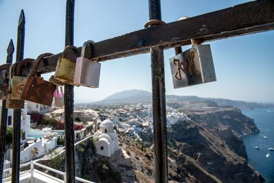 Close-up of padlocks on railing against sky