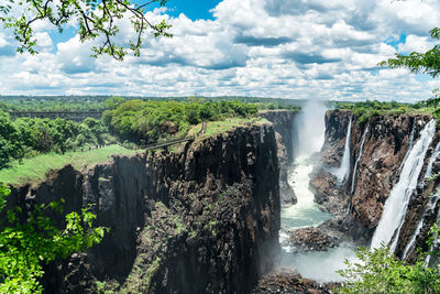 Scenic view of waterfall against sky