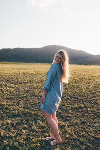 Woman standing on field against sky