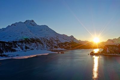 Scenic view of snowcapped mountains against sky during sunset