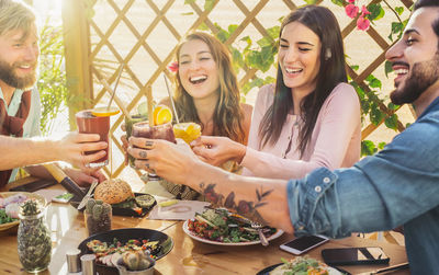 Men and women toasting drinks over table at restaurant