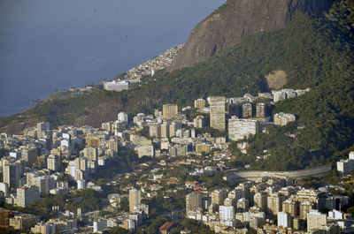 Scenic view of houses by mountain at morro dois irmaos against sea