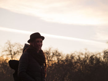 Portrait of smiling woman standing against sky