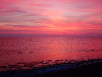 Scenic view of sea against dramatic sky during sunset