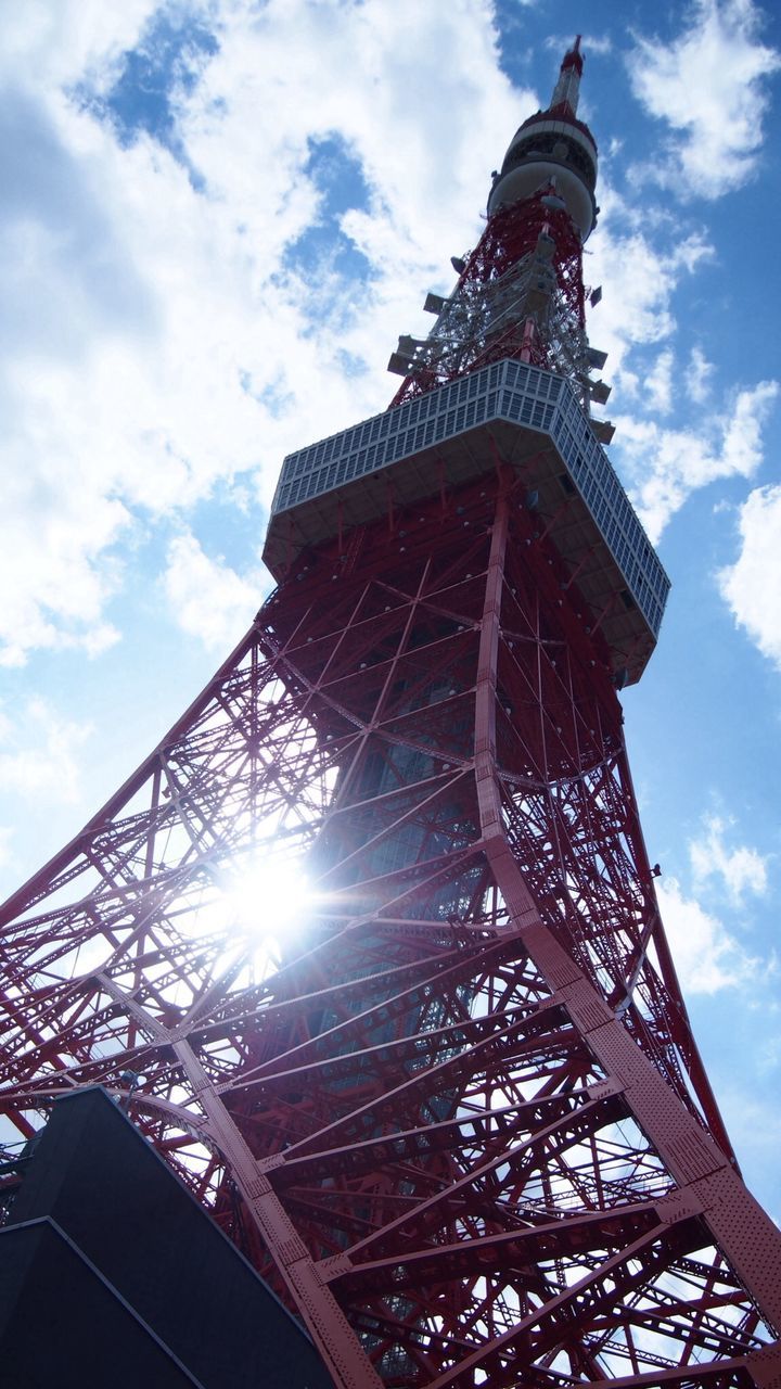 low angle view, architecture, built structure, tower, sky, tall - high, famous place, travel destinations, international landmark, building exterior, tourism, sun, capital cities, cloud - sky, eiffel tower, travel, architectural feature, metal, sunlight, sunbeam