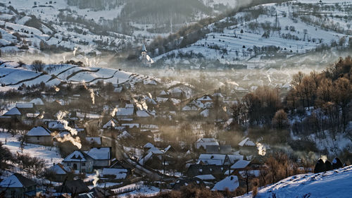 High angle view of snow covered trees and buildings