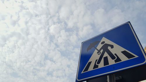 Low angle view of road sign against sky