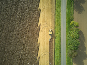 Drone aerial shots of a tractor ploughing a field at stone creek, sunk island, east yorkshire, uk.