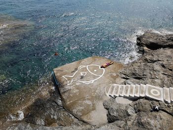 High angle view of text on rock by sea