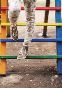 Woman's legs in the colorful children playground