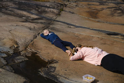 High angle view of people lying on rock