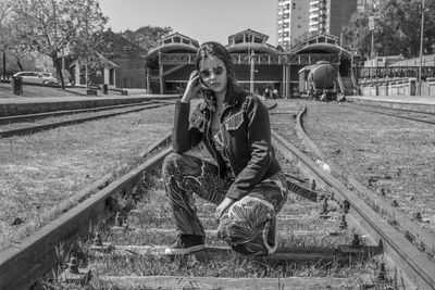 Portrait of man sitting on railroad track